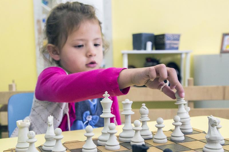 Crianças jogando xadrez no jardim de infância ou na escola primária. jogo  de xadrez infantil.