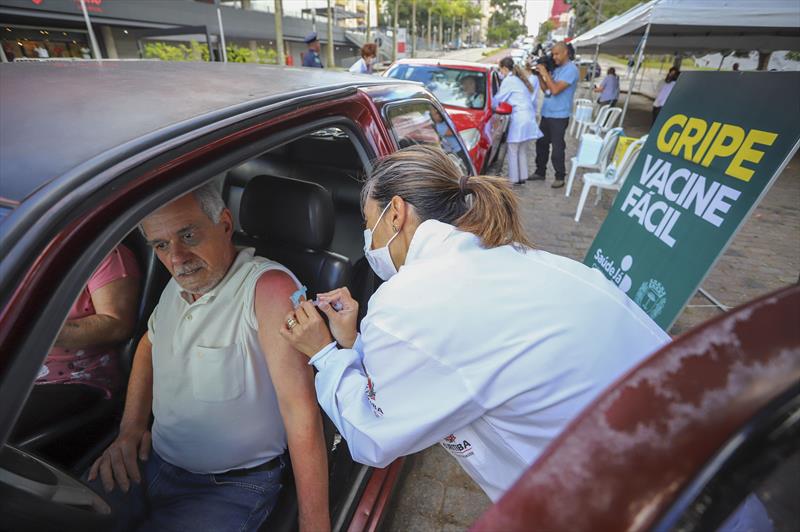Inicio da Campanha de vacinação contra a gripe para idosos em Curitiba. Na imagem profissionais de saúde aplicam vacinas para idosos que não precisam sair do veiculo, em um dos pontos na Praça do Atlético - Curitiba 23/03/2020 - Foto: Daniel Castellano / SMCS