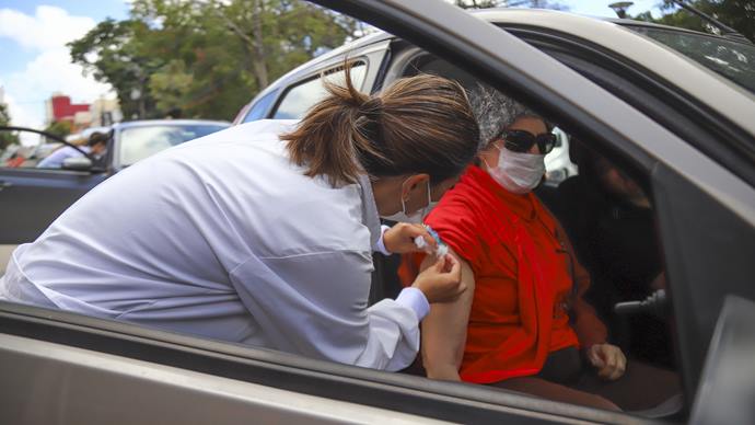 Inicio da Campanha de vacinação contra a gripe para idosos em Curitiba. Na imagem profissionais de saúde aplicam vacinas para idosos que não precisam sair do veiculo, em um dos pontos na Praça do Atlético - Curitiba 23/03/2020 - Foto: Daniel Castellano / SMCS
