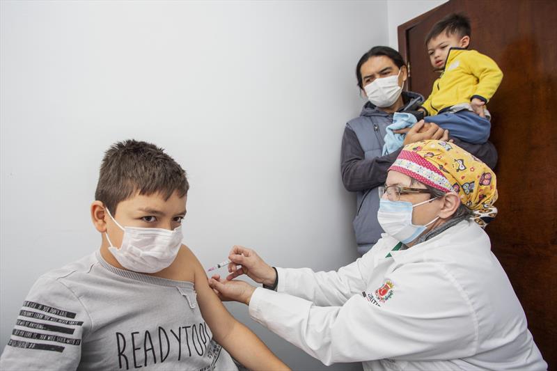 Pais levam filhos para tomar vacina contra a gripe na Unidade de Saúde Vila Feliz. Na imagem: Ainran Matsuno, nove anos. Curitiba, 24/05/2022. Foto: Ricardo Marajó/SMCS