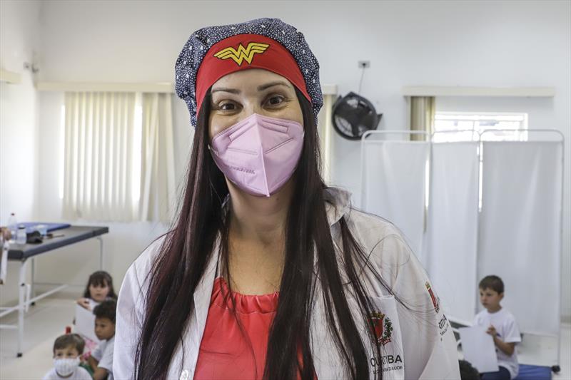 Crianças aprendem sobre importância da vacinação durante "aula" em unidade de saúde. Na imagem, a auxiliar de enfermagem Cristine Dias. Curitiba, 26/10/2022. Foto: Hully Paiva/SMCS