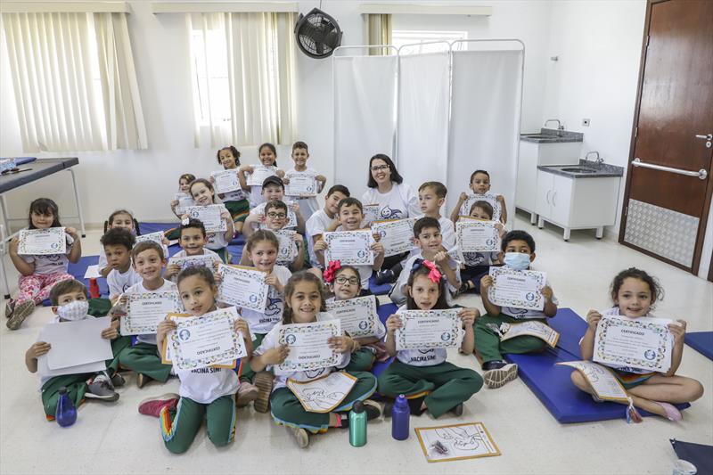 Crianças aprendem sobre importância da vacinação durante "aula" em unidade de saúde. Na imagem, a Gilcelli Vidal e sua turma. Curitiba, 26/10/2022. Foto: Hully Paiva/SMCS