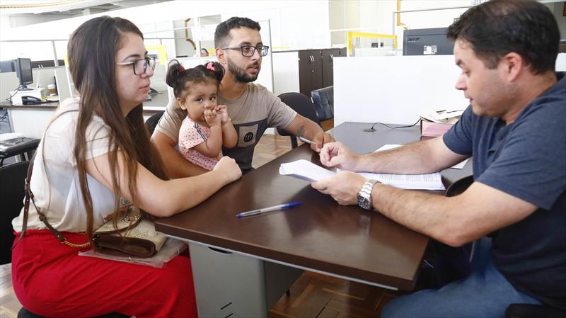 Contemplados na fila da Cohab vieram até a Sede da Companhia para assinar o contrato de compra e venda. Na imagem Ricardo, sua esposa Daiane e sua filha. 
Curitiba, 21/03/2023. 
Foto: Rafael Silva / Cohab 