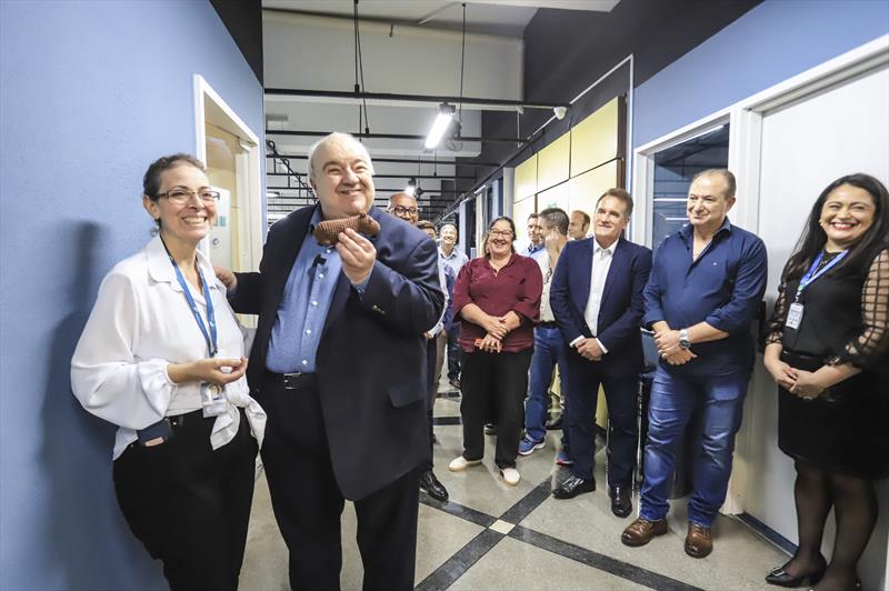 Prefeito Rafael Greca acompanhado do Presidente do ICI, Maurício Gonçalves Pimentel, visita as novas instalações da Central 156 de atendimento e informações ao cidadão, nas dependências do Instituto das Cidades Inteligentes (ICI).
Na imagem, O Prefeito recebe presente de Stela Feltran,  atendente do 156, confeccionado por ela mesmo.
Curitiba, 12/04/2023.
Foto: José Fernando Ogura/SMCS.