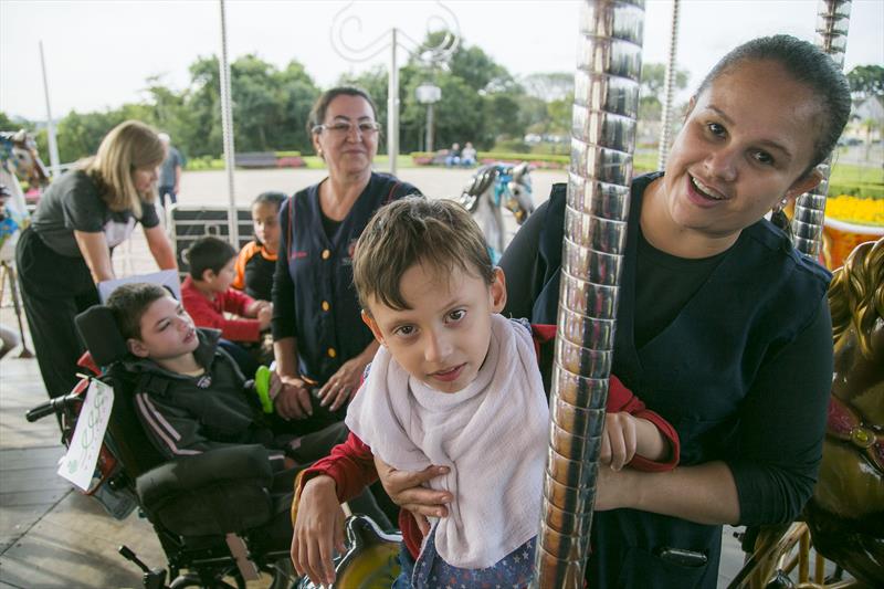 Alunos com paralisia cerebral da Escola Vivian Marçal Mercês, brincam no carrossel do Parque Tanguá. Curitiba, 26/05/2023. Foto: Pedro Ribas/SMCS