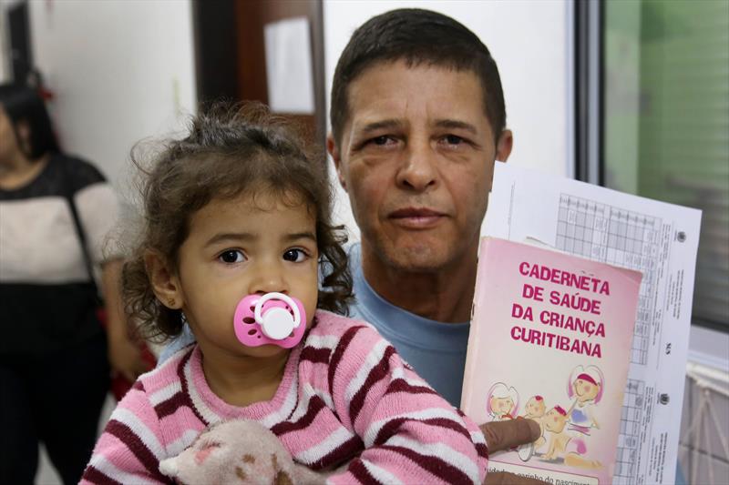 Vacinação no centro de educação infantil Santa Rita, no Tatuquqra..Na imagem, Francisco Reinaldo Neves e a filha Alice.Curitiba, 27/11/2023.Foto: Luiz Costa /SME.